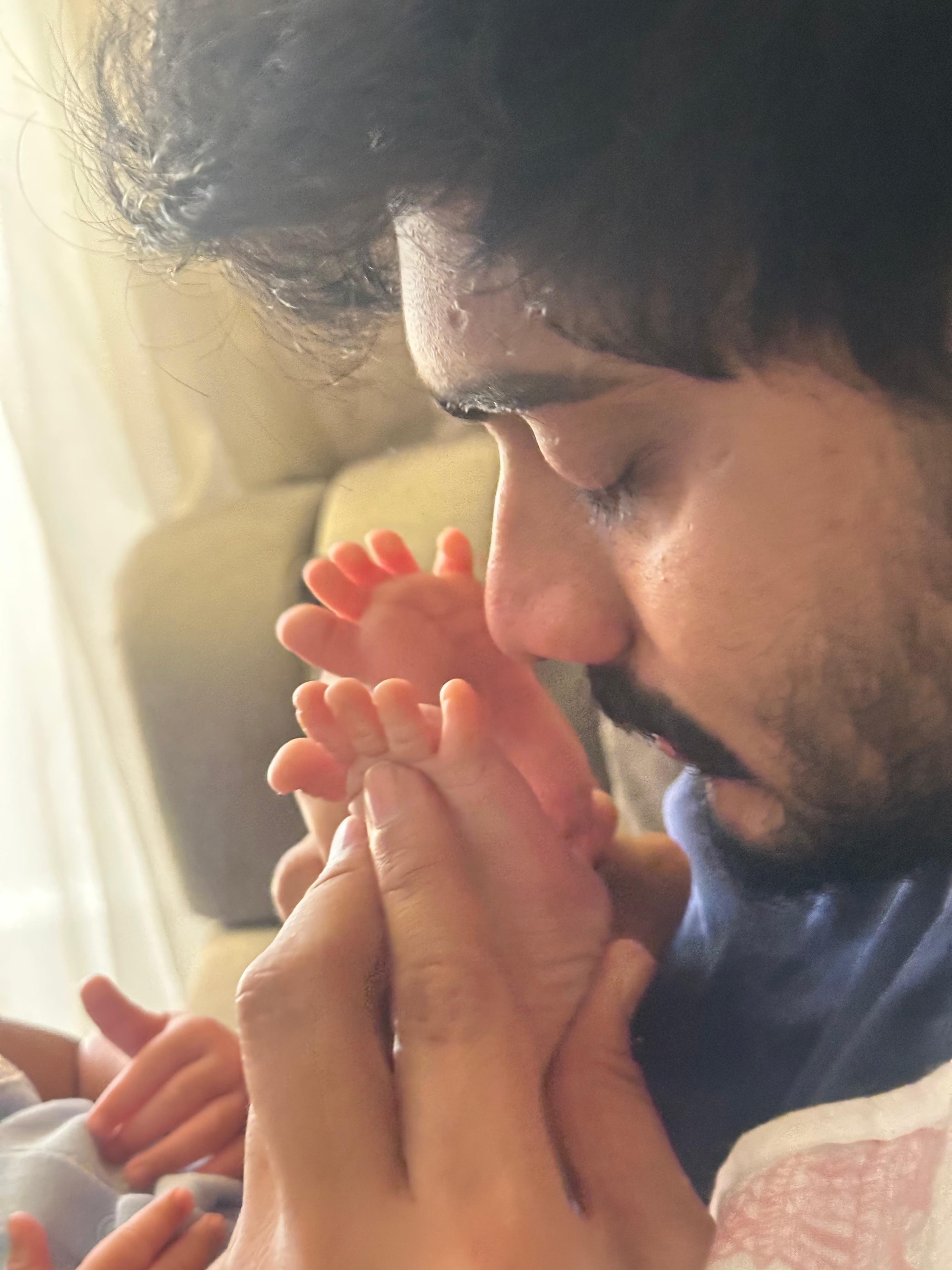 Papa kissing her tiny feet.